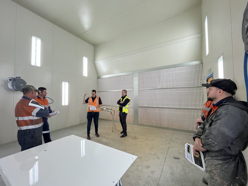 A team of expert workers discuss Truflow spray booth construction and Spray Booth certification